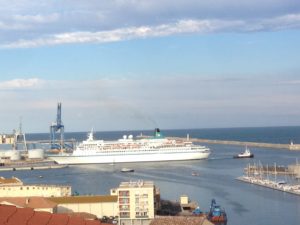 Passenger ship being manouvered by tug boat